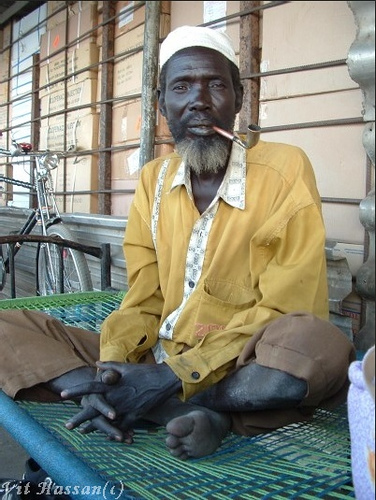 Old man from a Denka tribe smoking a traditional handmade pipe-they called "Aging". Denka